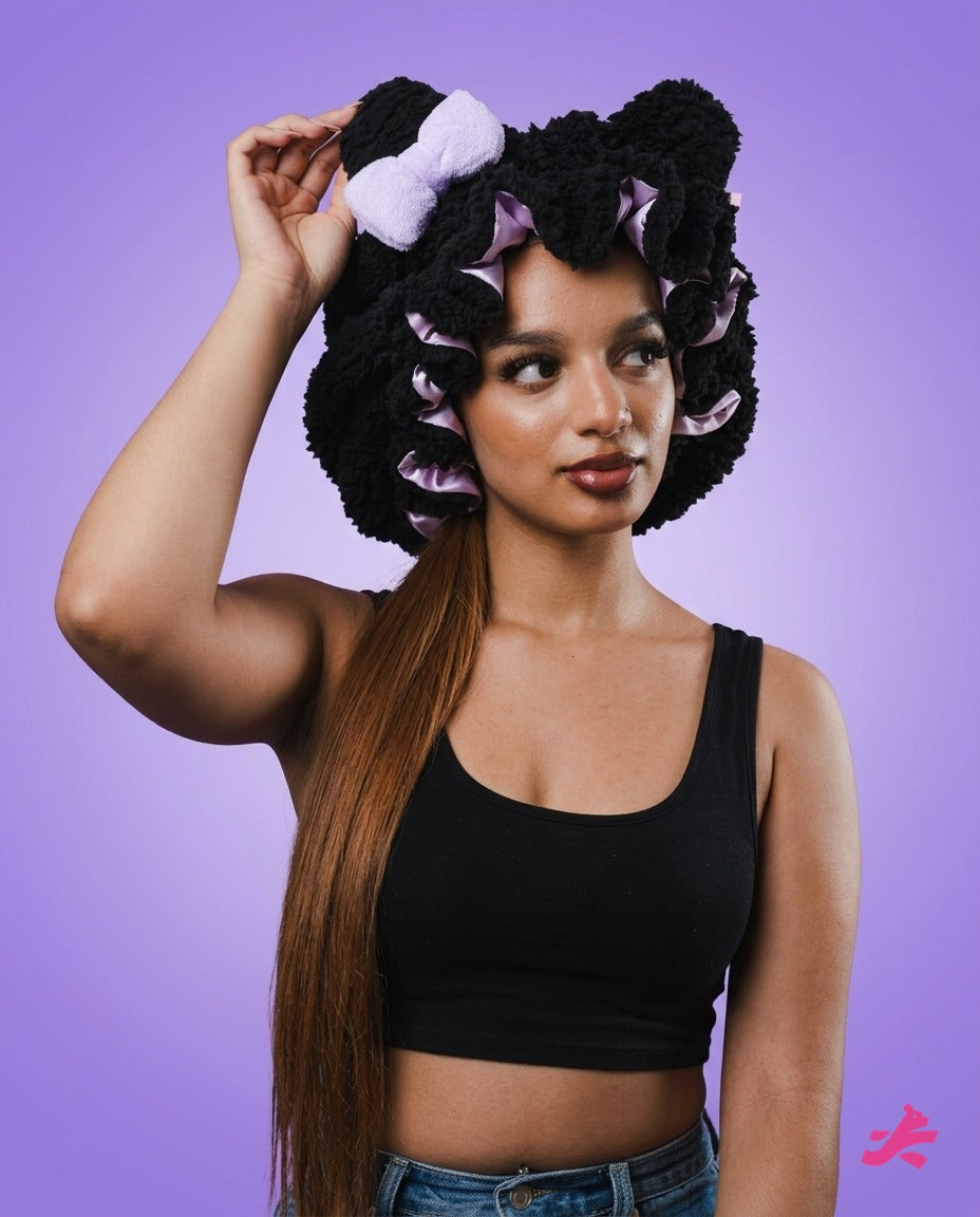 Black plush teddy bonnet worn with arm raised, on lilac