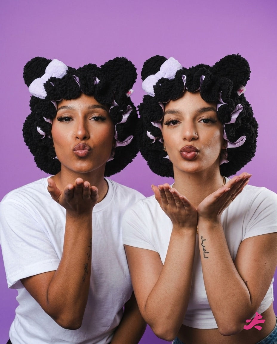Two friends blowing kisses in black plush teddy bonnets