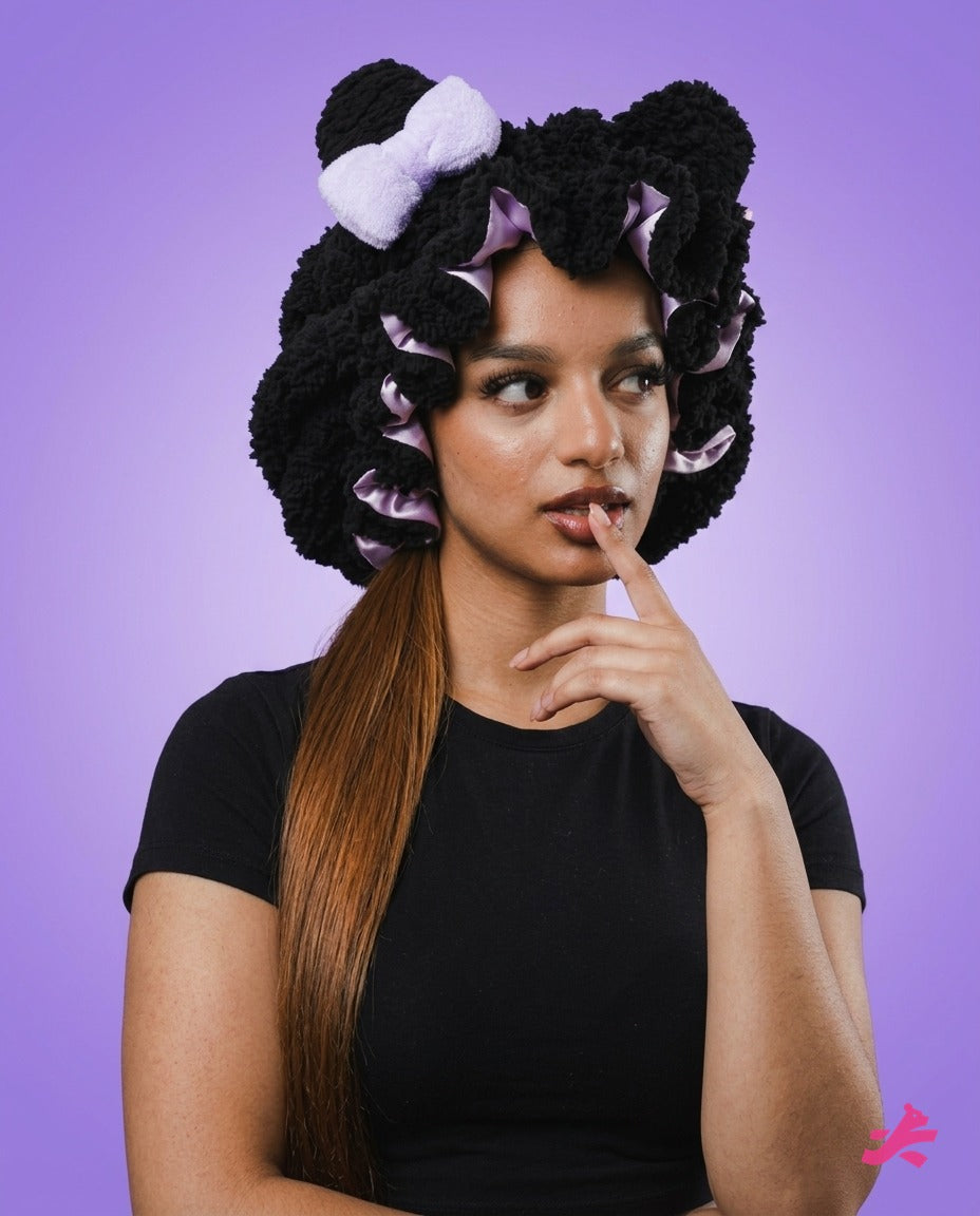 Black plush teddy bonnet, front view, on lilac